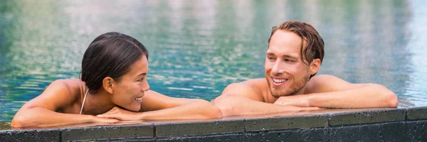 Wellness spa pool couple relaxing in hydrotherapy luxury travel resort on tropical holidays together enjoying the swim in water. Banner panorama. Hotel swimming pool — Stock Photo, Image