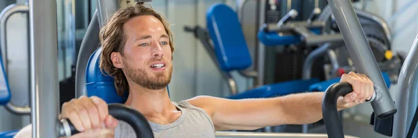 Man doing chest exercises on bench press machine — Stock Photo, Image