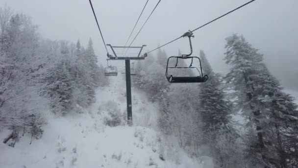 Impianti di risalita paesaggio invernale con neve e alberi. Bel tempo nevoso in una giornata estremamente fredda nella stazione sciistica con la classica seggiovia — Video Stock