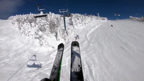 Ski winter vacation concept video. Ski lift and gondola. First person view POV with skis. Skiing on snow slopes in the mountains, People having fun on a snowy day - Winter sport outdoor activity — Stock Video
