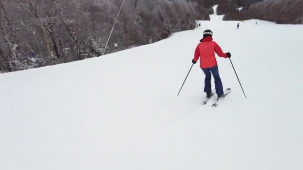 Esquí alpino. Esquí mujer esquiadora dowhill va contra los árboles cubiertos de nieve fondo en invierno Mujer en chaqueta de esquí rojo. Mont Tremblant, Quebec, Canadá. — Vídeos de Stock