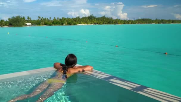 सीमलेस लूप वीडियो: सेक्सी बिकिनी बॉडी महिला लक्जरी पूल में तैराकी आराम कर रही — स्टॉक वीडियो