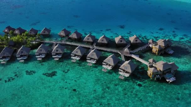 Vídeo aéreo de vacaciones turísticas con bungalows sobre el agua en el arrecife de coral mar — Vídeos de Stock