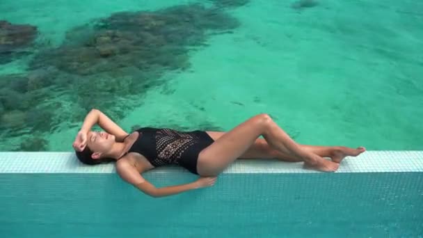 Maillot de bain sexy modèle femme bronzage couché sur la piscine vacances de luxe station — Video