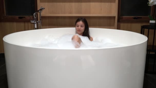 Femme de bain relaxant dans le bain à remous dans la chambre suite hôtel resort profiter de soins — Video