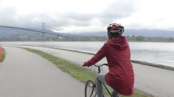 Cyklista na kole ve Stanley Parku u mostu Lions Gate na Vancouver Seawall — Stock video