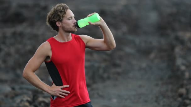 Homme boire de l'eau de la bouteille après l'entraînement de course de remise en forme à l'extérieur — Video