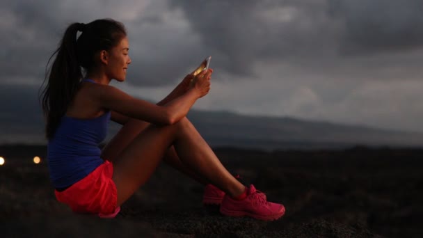 Phone - Woman using smart phone looking at fitness tracking app running at night — Stock Video