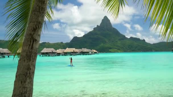 Hotel liburan pantai Tahiti di Bora Bora, Polinesia Prancis. Paddleboarding kegiatan liburan olahraga air SUP wanita dayung, Polinesia Prancis. Gunung Otemanu lanskap — Stok Video