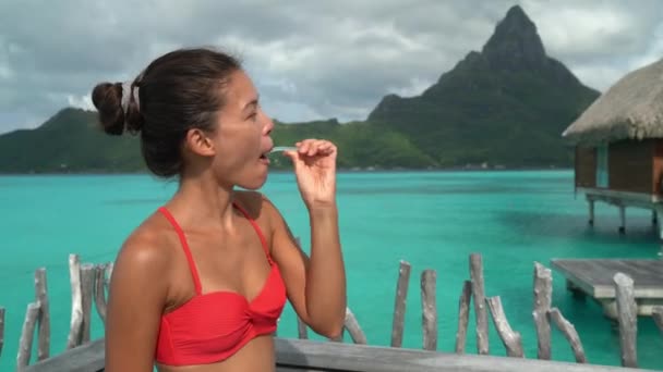 Žena čistí zuby a drží kartáček. Zubní péče portrét krásné dívky čištění zubů s úsměvem šťastný na cestovní dovolenou na Bora Bora luxusní resort. Multiraciální žena — Stock video