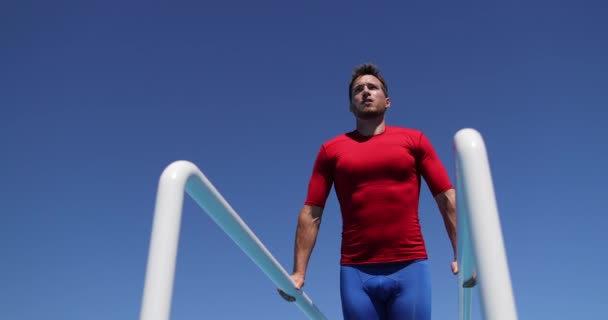 Hombre de fitness levantando piernas en barra bastidor de ajuste cruzado fuera de los abdominales de entrenamiento — Vídeos de Stock