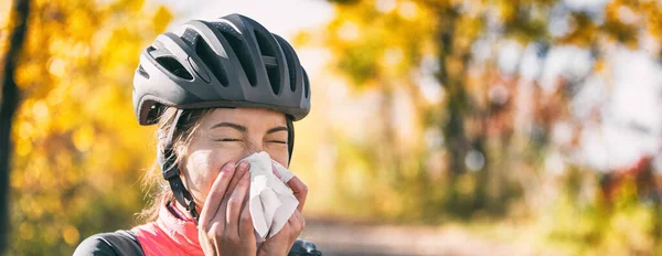 Toux dans les tissus recouvrant le nez et la bouche en toussant à l'extérieur comme directives d'hygiène COVID-19 pour la prévention de la propagation du coronavirus. Vélo cycliste fille éternuer dans le papier à l'extérieur. Bannière panoramique — Photo