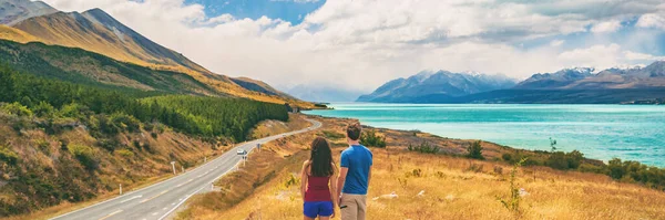 Nueva Zelanda viaja gente mirando el Monte Cook Aoraki lejos en el paisaje. Pareja de turistas caminando en el mirador de Peters, espacio de copia panorámica de la bandera en el fondo — Foto de Stock