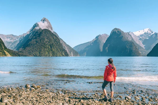 Nova Zelândia - casal de turistas caminhadas olhando para Milford Sound desfrutando de vista icônica e destino turístico famoso no Fiordland National Park, South Island, Nova Zelândia — Fotografia de Stock