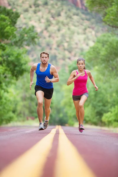 Pareja corriendo concentrada en la carretera — Foto de Stock