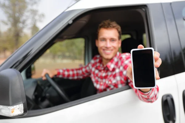 Человек в машине показывает смартфон — стоковое фото