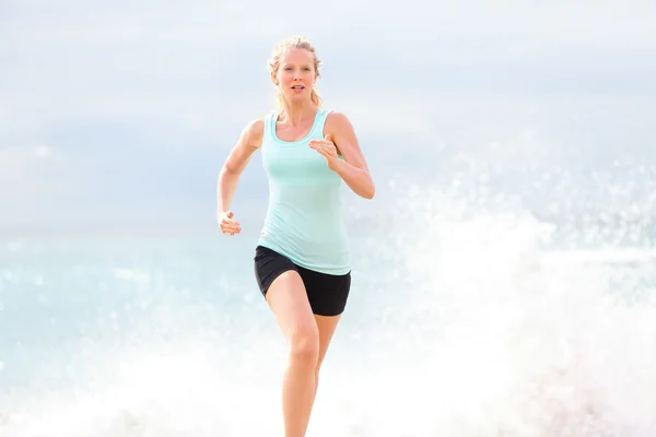 Žena jogging na pláži — Stock fotografie