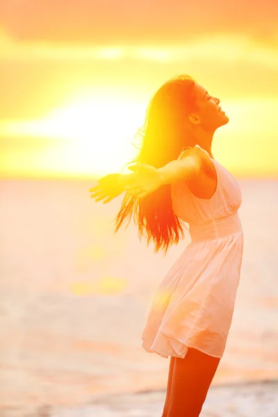 Mulher desfrutando do pôr do sol na praia — Fotografia de Stock