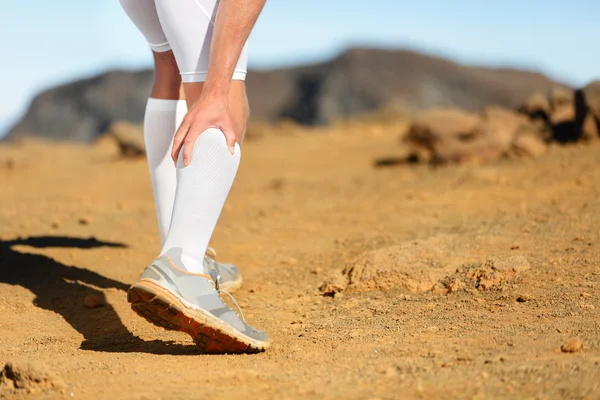 Um homem a correr ao ar livre. Lesões desportivas — Fotografia de Stock