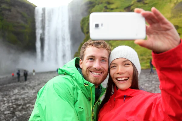 Paret tar bild vattenfall på smartphone — Stockfoto