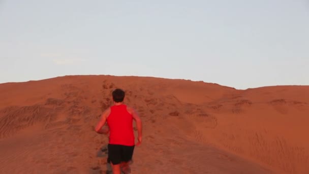 Біг чоловік у пустелі — стокове відео