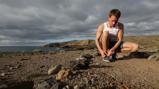 Uomo allacciatura scarpe sul sentiero all'aperto — Video Stock