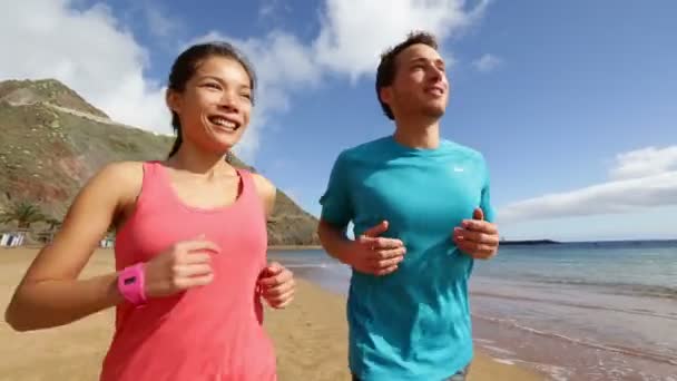 Frau und Mann joggen am Strand — Stockvideo