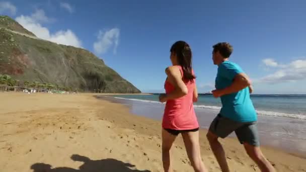 Pareja trotando en la playa — Vídeo de stock