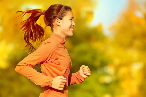 Kobieta biegająca w jesiennym lesie — Zdjęcie stockowe