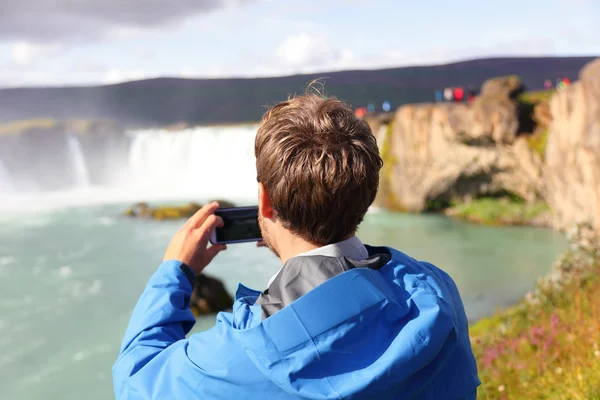 Tourist taking photo of waterfall — Stock Photo, Image