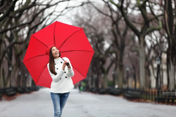 Frau mit rotem Regenschirm zu Fuß — Stockfoto