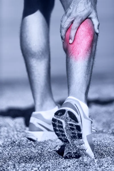 Man running clutching calf muscle — Stock Image Man running clutching calf muscle Stock Picture