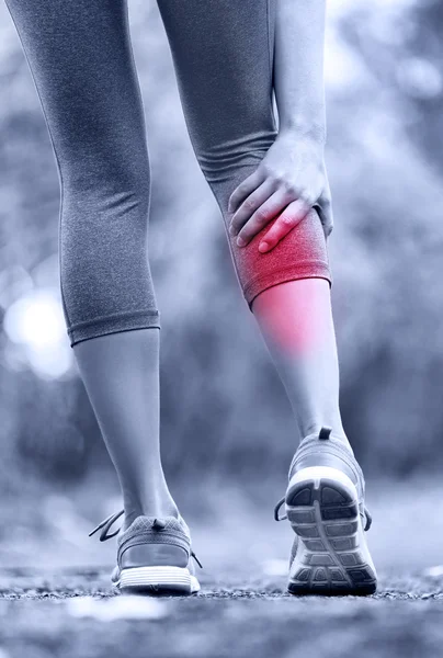 Woman running clutching calf muscle — Stock Image Woman running clutching calf muscle Royalty Free Stock Photos