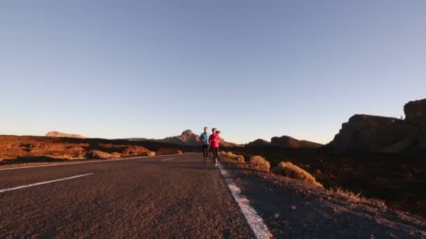 Mujer y hombre corriendo por la carretera — Vídeos de Stock