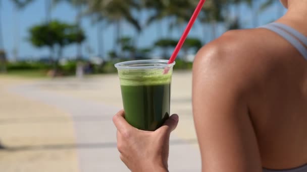 Фитнес-женщина пьет зеленый сок — стоковое видео