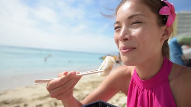 Mujer comiendo sushi llevar a la playa — Vídeos de Stock