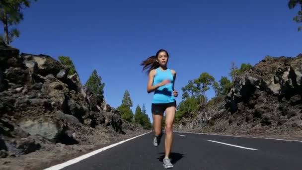 Vrouw joggen op bos bergweg — Stockvideo