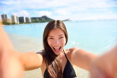 Woman taking selfie at beach clipart