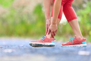 Female runner touching foot in pain clipart