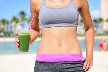 Fitness woman drinking vegetable smoothie clipart