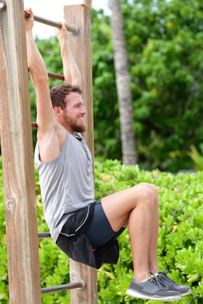 Músculos de entrenamiento del hombre con levantamiento de piernas —  Fotos de Stock