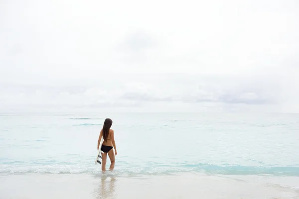 Девушка-серфингистка собирается заняться серфингом в океане — стоковое фото