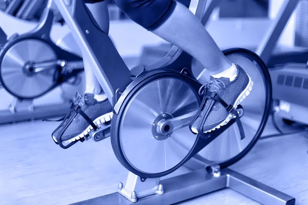Kobieta wycięciem, jazda na rowerze w centrum fitness — Zdjęcie stockowe