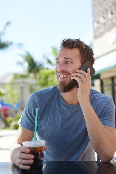Человек в кафе, разговаривающий со смартфоном — стоковое фото