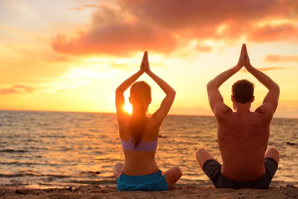 Pareja haciendo meditación en la playa — Foto de Stock