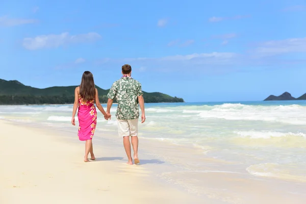 Couple de jeunes mariés marchant sur la plage tropicale — Photo