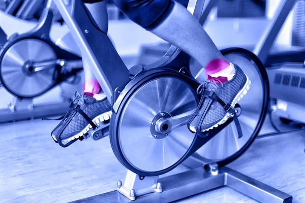 Beine einer Sportlerin mit Fahrrad-Maschine — Stockfoto