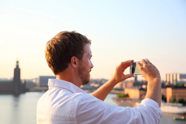 Turista tomando fotografías del atardecer en Estocolmo —  Fotos de Stock