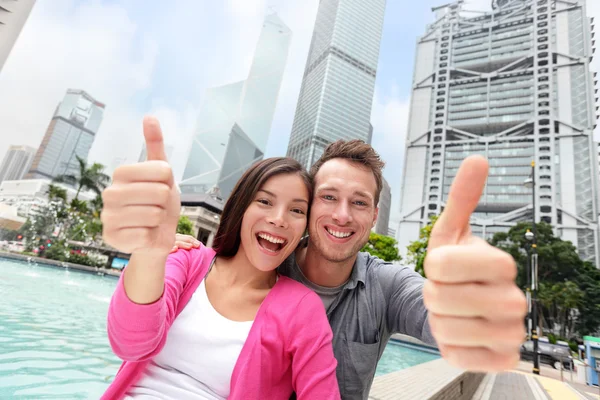 Tourists couple showing thumbs up in Hong Kong — Stock Photo, Image