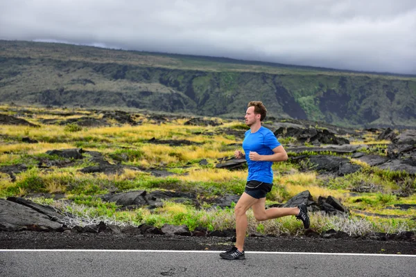 Corredor masculino correndo na estrada da montanha — Fotografia de Stock